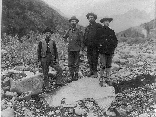 Four Men Standing on Nugget of Copper